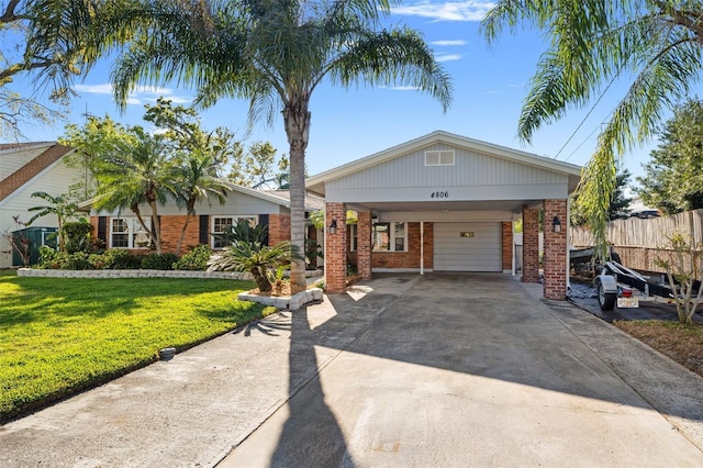 view of front of home with a front lawn, driveway, an attached carport, fence, and brick siding