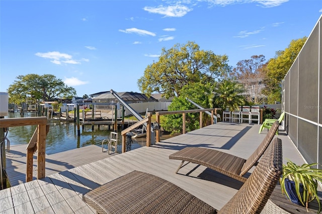 dock area with glass enclosure, a water view, and boat lift