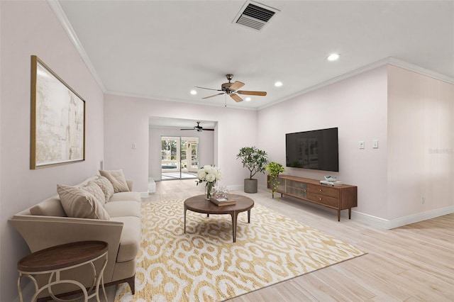 living room with visible vents, baseboards, ornamental molding, wood finished floors, and a ceiling fan