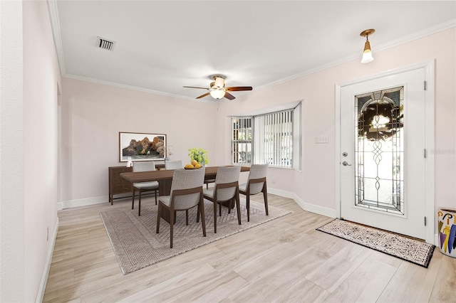 dining room featuring visible vents, crown molding, a ceiling fan, and wood finished floors