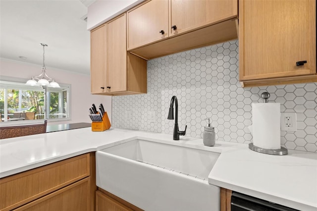 kitchen with a sink, backsplash, and light countertops