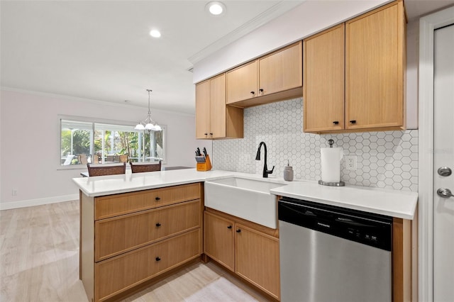 kitchen with a peninsula, ornamental molding, a sink, stainless steel dishwasher, and tasteful backsplash