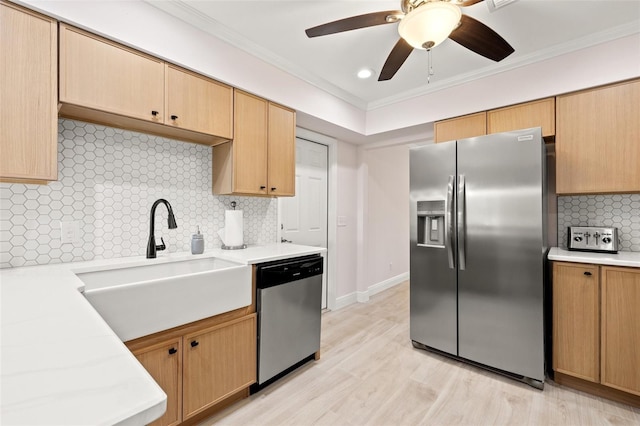 kitchen featuring a sink, appliances with stainless steel finishes, crown molding, light countertops, and ceiling fan