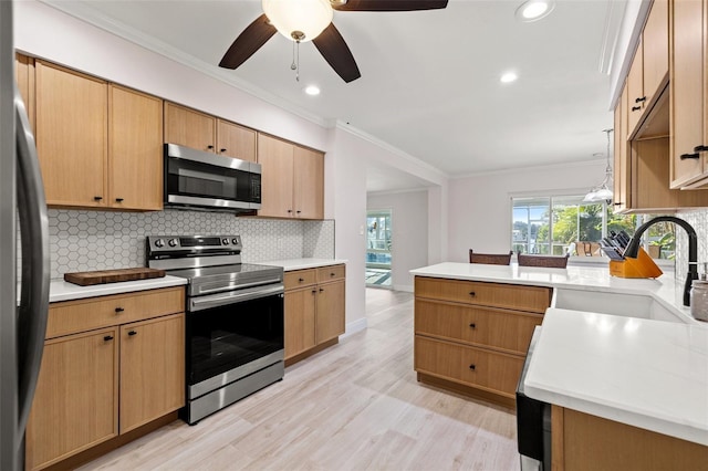 kitchen featuring a sink, tasteful backsplash, appliances with stainless steel finishes, crown molding, and light countertops