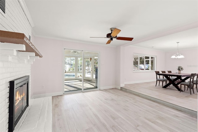 living room featuring light wood-type flooring, plenty of natural light, and ornamental molding