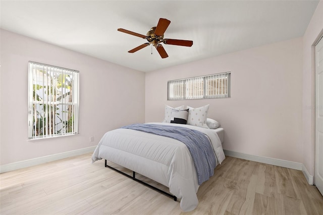 bedroom with baseboards, light wood finished floors, and ceiling fan