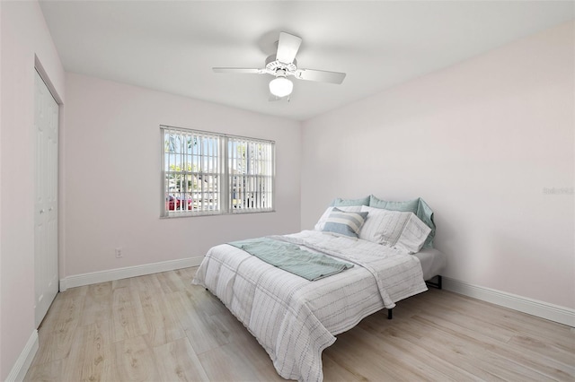 bedroom featuring light wood-style flooring, baseboards, and ceiling fan