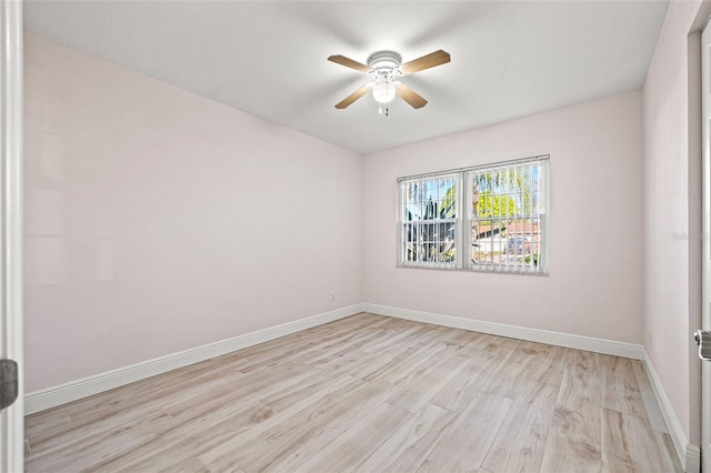 empty room featuring light wood-type flooring, baseboards, and ceiling fan