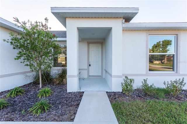 entrance to property with stucco siding