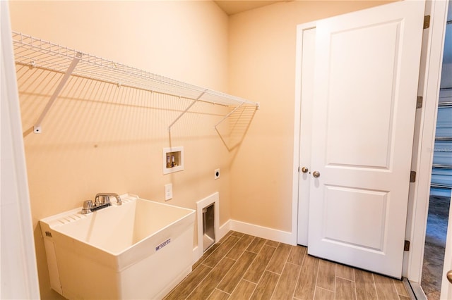 washroom with hookup for a washing machine, baseboards, wood finish floors, laundry area, and electric dryer hookup