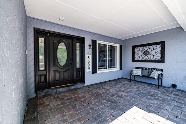 entrance to property featuring stucco siding