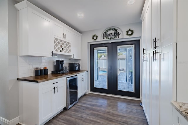 kitchen with beverage cooler, decorative backsplash, french doors, white cabinets, and dark wood-style flooring