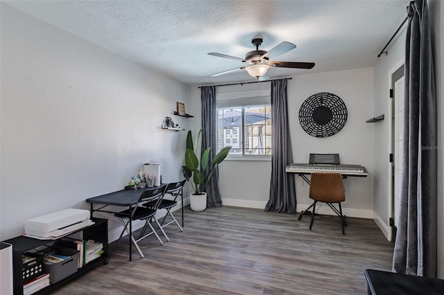 office space with baseboards, a textured ceiling, a ceiling fan, and wood finished floors