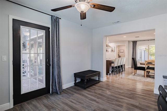 foyer with visible vents, baseboards, a ceiling fan, and dark wood-style flooring