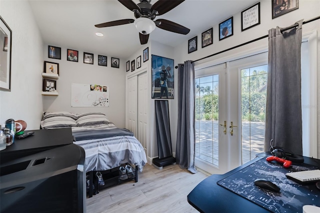 bedroom featuring wood finished floors, ceiling fan, french doors, a closet, and access to outside