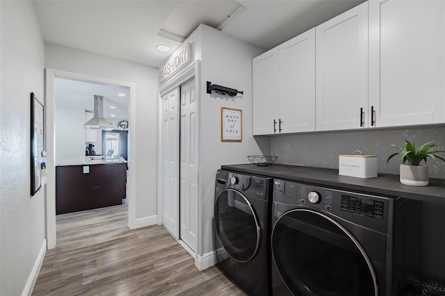 laundry area featuring wood finished floors, baseboards, recessed lighting, cabinet space, and washing machine and dryer