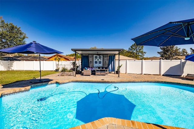 view of pool with a fenced backyard, a yard, an outdoor structure, a fenced in pool, and a patio area