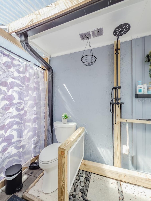 bathroom with a shower with shower curtain, visible vents, and toilet