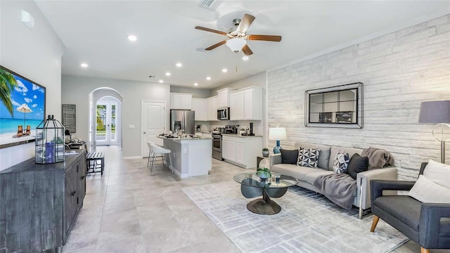 living area featuring visible vents, recessed lighting, arched walkways, baseboards, and ceiling fan