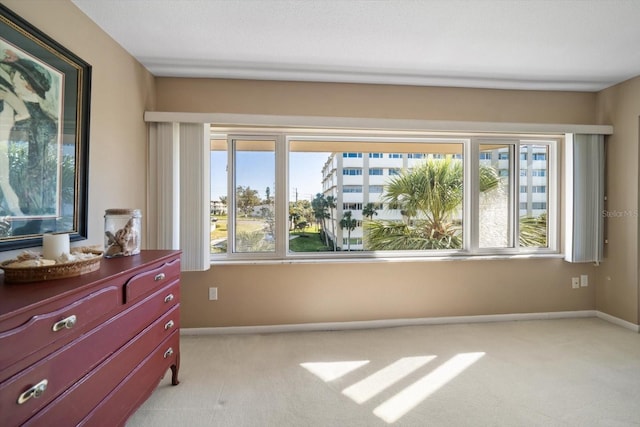 bedroom with baseboards and light carpet