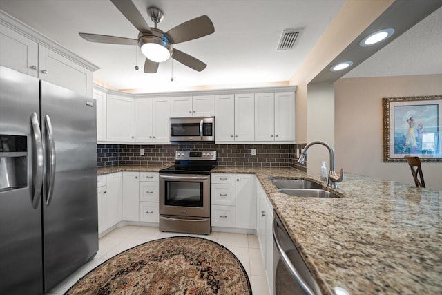 kitchen featuring a sink, decorative backsplash, light tile patterned floors, and stainless steel appliances