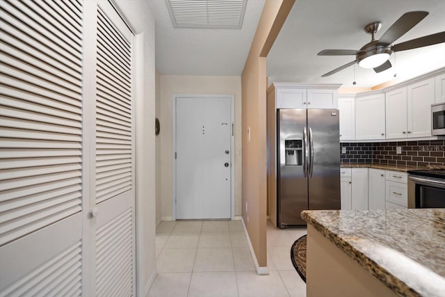 kitchen with visible vents, decorative backsplash, stainless steel appliances, light tile patterned flooring, and white cabinetry