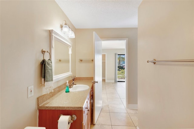 bathroom featuring vanity, tile patterned floors, baseboards, and a textured ceiling