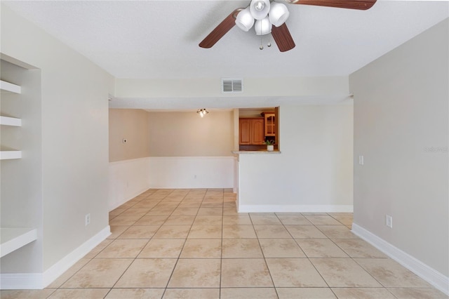 spare room featuring light tile patterned floors, visible vents, and ceiling fan