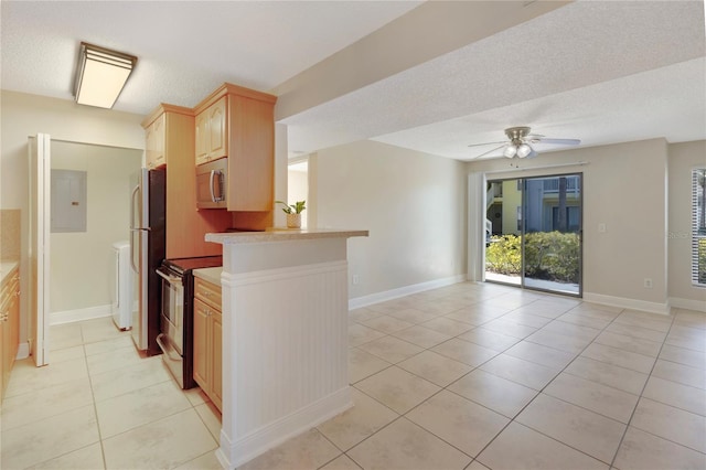 kitchen featuring a ceiling fan, open floor plan, appliances with stainless steel finishes, light countertops, and light tile patterned floors