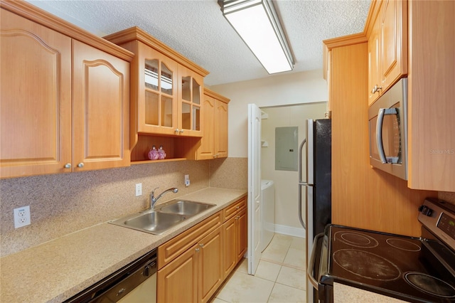 kitchen featuring light countertops, electric panel, light tile patterned floors, appliances with stainless steel finishes, and a sink