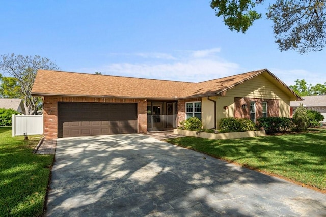 ranch-style house with driveway, a front lawn, fence, an attached garage, and brick siding