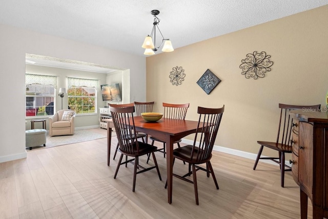 dining area with light wood-type flooring and baseboards