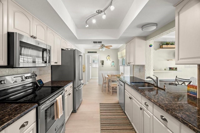 kitchen with visible vents, a sink, stainless steel appliances, light wood-style floors, and a raised ceiling