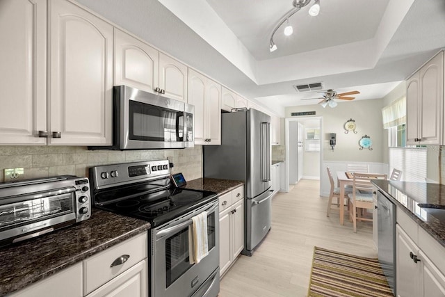 kitchen with visible vents, appliances with stainless steel finishes, a raised ceiling, and decorative backsplash