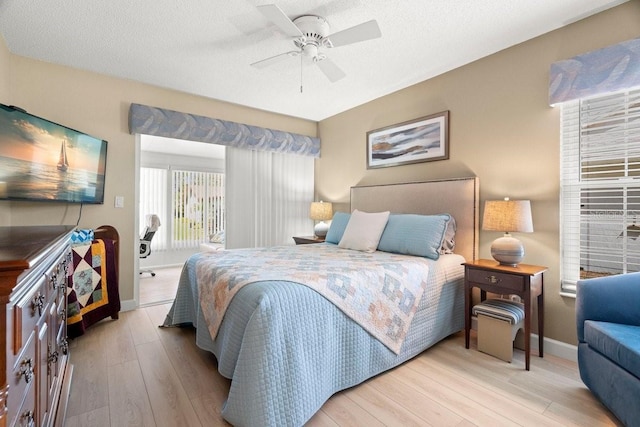 bedroom featuring wood finished floors, baseboards, ceiling fan, access to exterior, and a textured ceiling