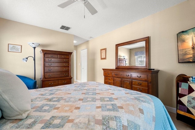 bedroom featuring baseboards, visible vents, ceiling fan, a closet, and a textured ceiling