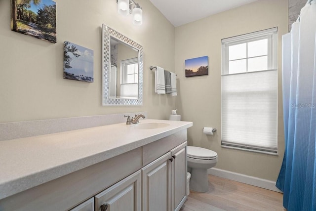 full bathroom featuring baseboards, toilet, wood finished floors, and vanity