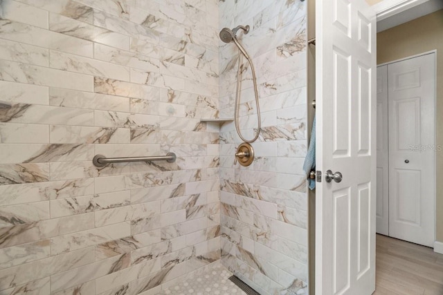 bathroom featuring a tile shower and wood finished floors