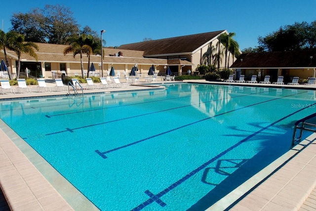 pool with a patio and fence