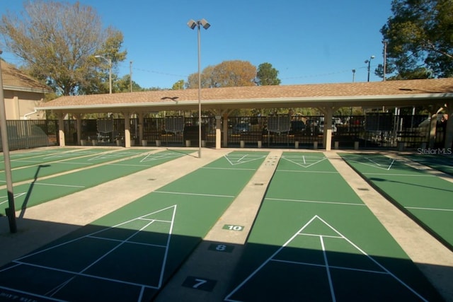 surrounding community with shuffleboard and fence