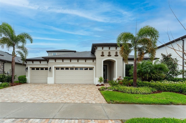 mediterranean / spanish-style home with decorative driveway, a garage, and stucco siding