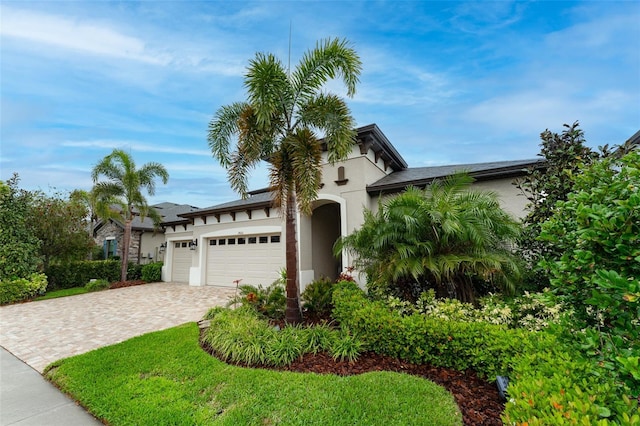 view of front of property featuring stucco siding, driveway, and an attached garage