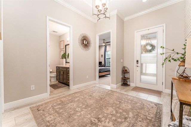 foyer entrance featuring visible vents, baseboards, a chandelier, and crown molding