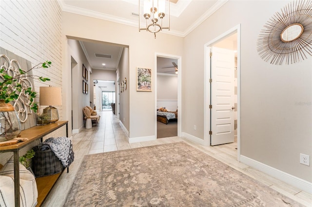 hall with visible vents, baseboards, and ornamental molding