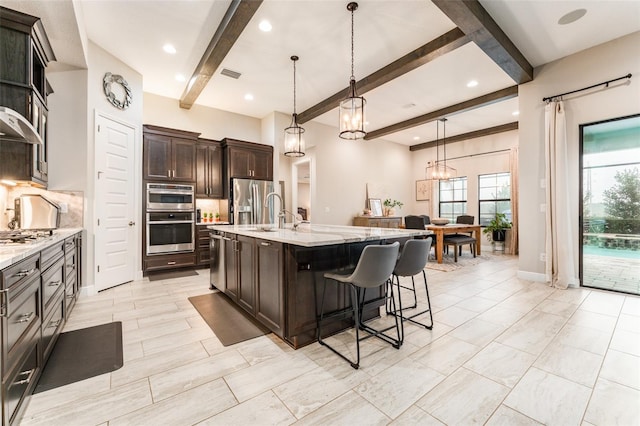 kitchen with visible vents, a breakfast bar, tasteful backsplash, stainless steel appliances, and dark brown cabinets