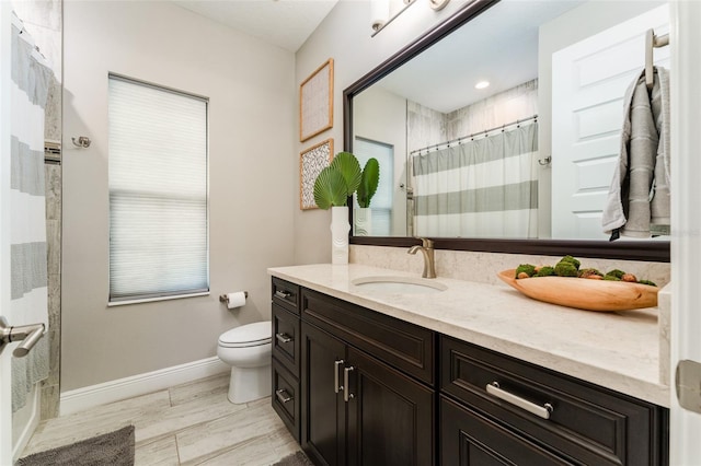 bathroom with curtained shower, toilet, vanity, and baseboards