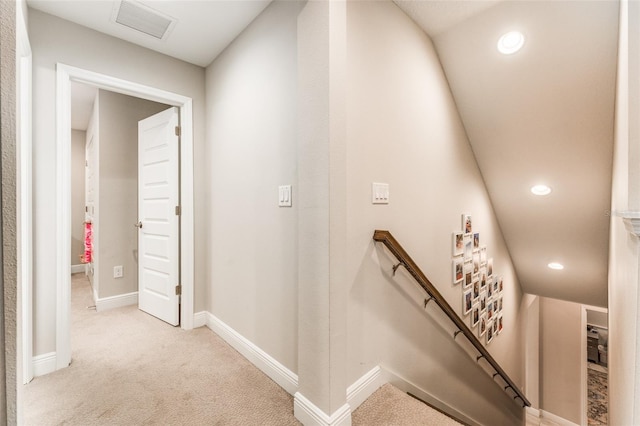 hallway with visible vents, baseboards, recessed lighting, an upstairs landing, and light colored carpet