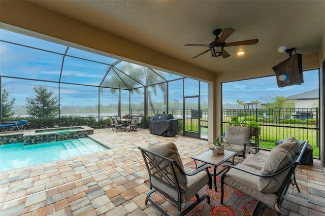 view of patio with a ceiling fan, a pool with connected hot tub, fence, glass enclosure, and a grill