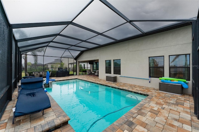 outdoor pool featuring a patio area and glass enclosure