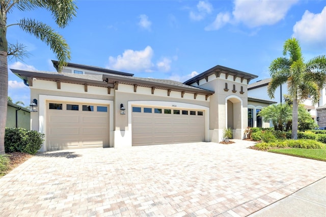 mediterranean / spanish-style house with decorative driveway, an attached garage, and stucco siding